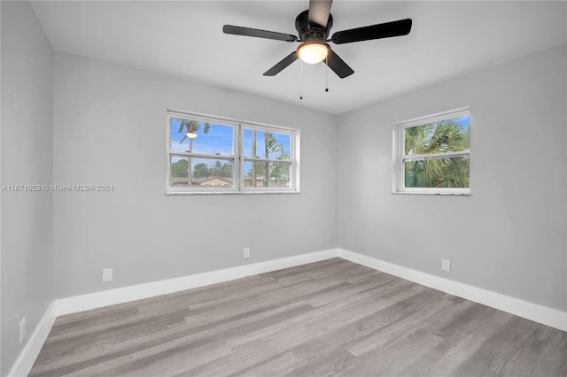 empty room with ceiling fan and light hardwood / wood-style flooring