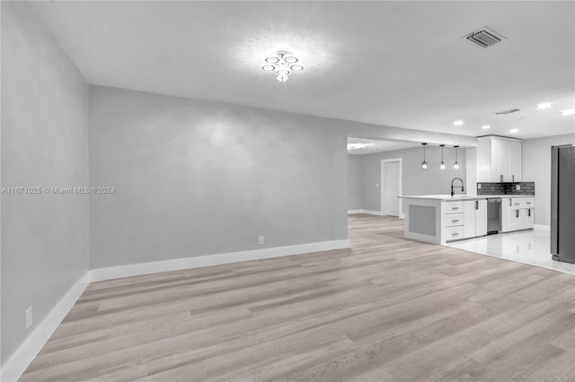 unfurnished living room with sink and light hardwood / wood-style flooring