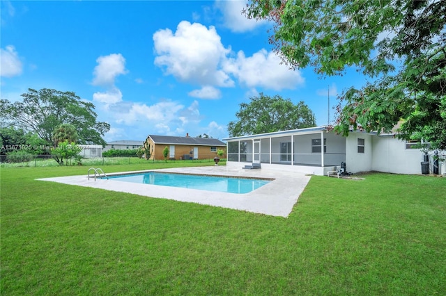 view of swimming pool featuring a yard, a sunroom, and a patio area