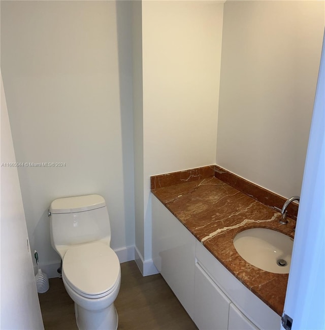 bathroom with vanity, toilet, and hardwood / wood-style flooring