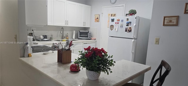 kitchen with sink, white appliances, and white cabinetry