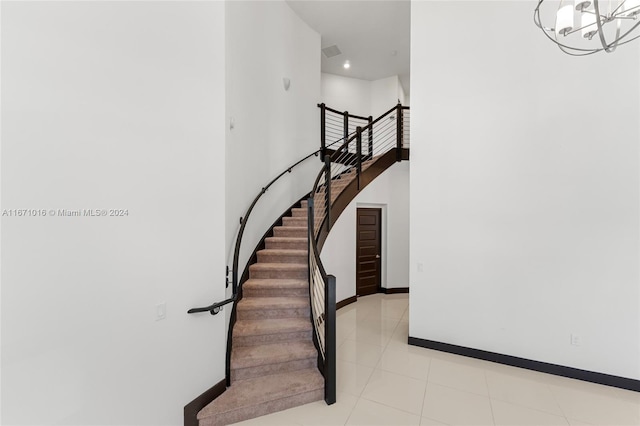 stairs with a notable chandelier and tile patterned flooring