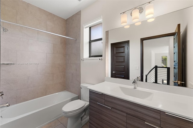 full bathroom featuring tiled shower / bath, vanity, toilet, and tile patterned floors