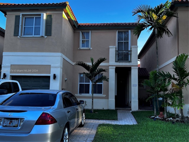 mediterranean / spanish-style home with a garage and a front yard