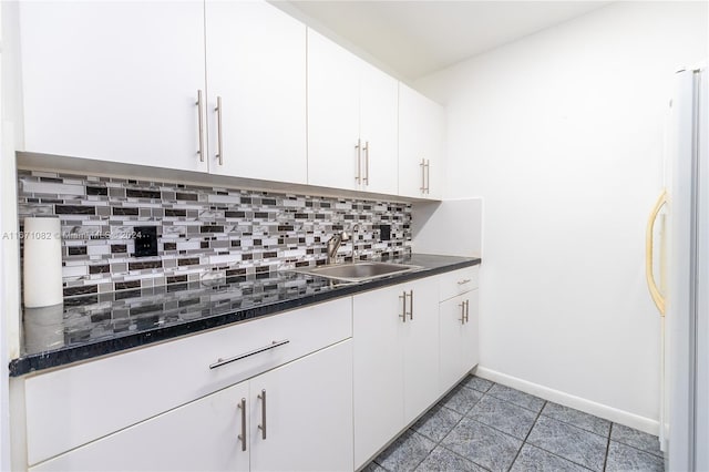 kitchen with decorative backsplash, white fridge, white cabinets, and sink