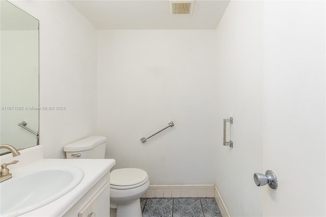 bathroom with tile patterned floors, vanity, and toilet