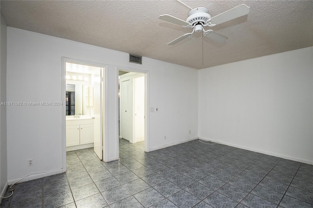 tiled empty room featuring ceiling fan, a textured ceiling, and sink