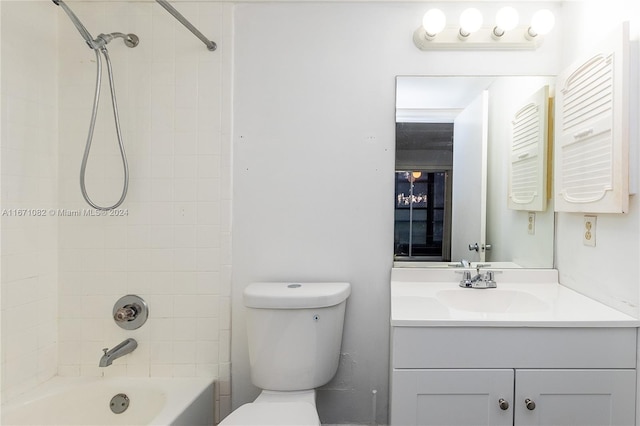 full bathroom with tiled shower / bath, vanity, and toilet