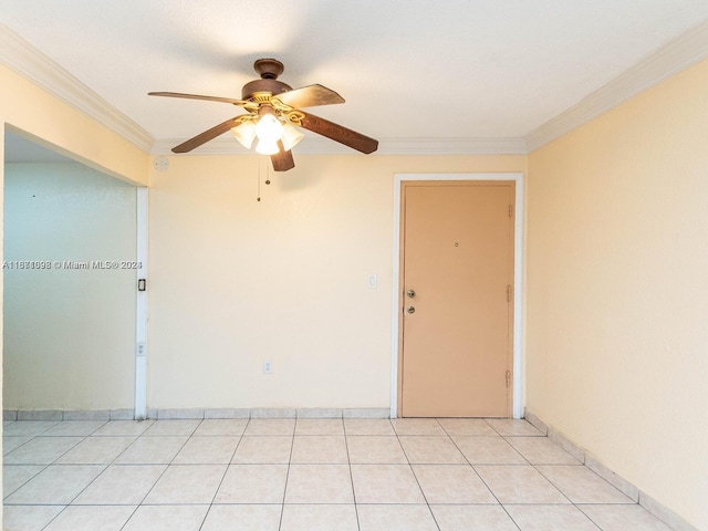 tiled spare room featuring ornamental molding and ceiling fan