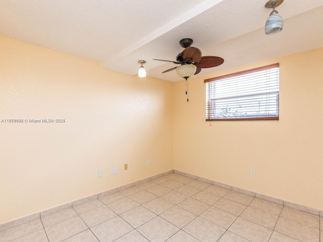 tiled spare room with ceiling fan, a textured ceiling, and beam ceiling