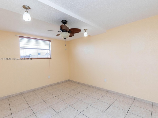 spare room with ceiling fan, a textured ceiling, and light tile patterned floors