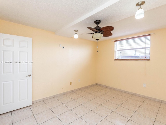 unfurnished room with a textured ceiling, light tile patterned flooring, and ceiling fan