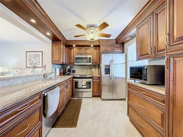 kitchen with appliances with stainless steel finishes, backsplash, light stone countertops, ornamental molding, and sink