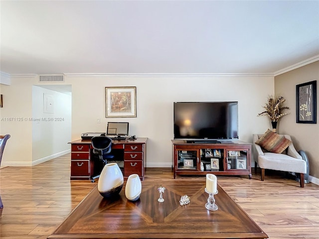 living area with light wood finished floors, visible vents, crown molding, and baseboards