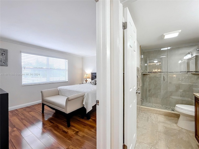 bedroom featuring baseboards, connected bathroom, and crown molding