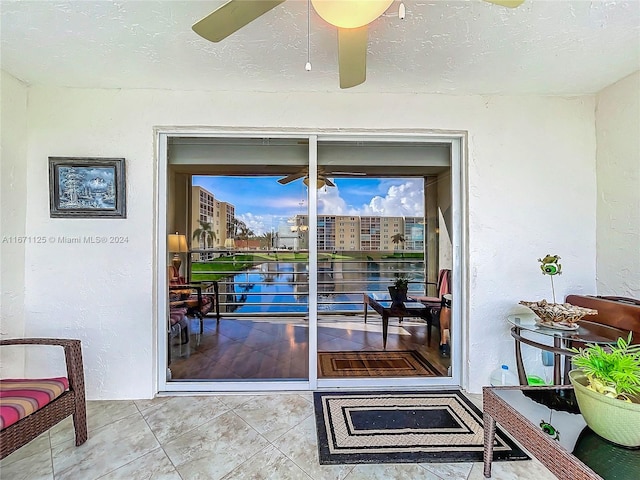 entryway featuring ceiling fan, tile patterned floors, and a textured ceiling