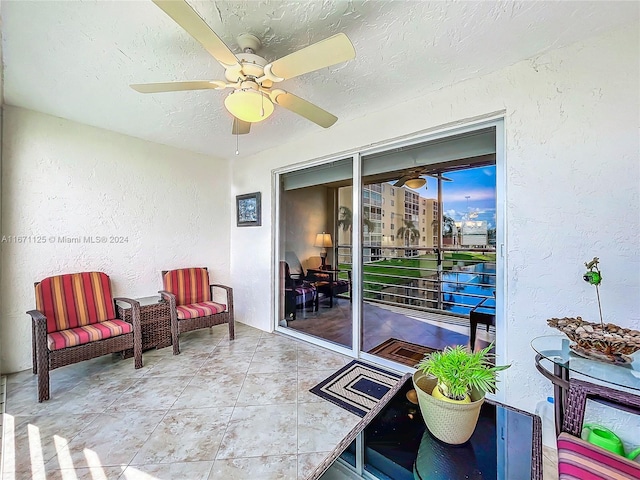 exterior space featuring a textured ceiling, light tile patterned floors, and ceiling fan