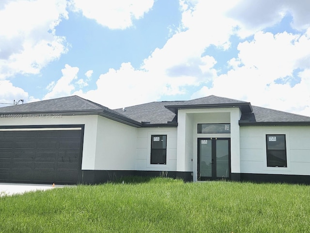 back of property with a garage and a lawn