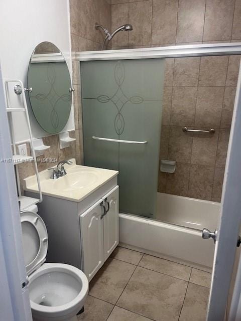 full bathroom featuring shower / bath combination with glass door, vanity, toilet, and tile patterned floors