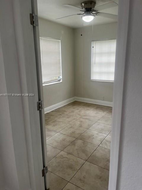 tiled empty room with ceiling fan