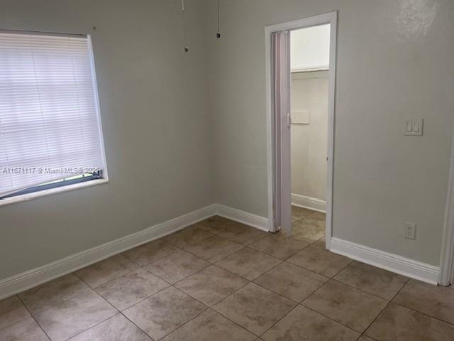 spare room featuring ceiling fan and light tile patterned floors