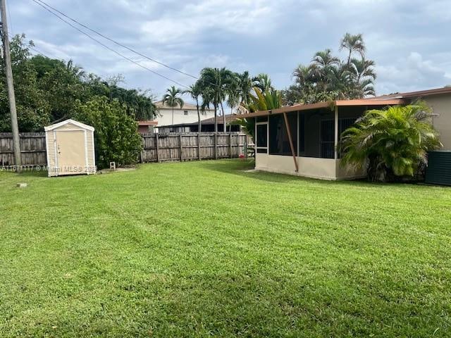 view of yard with a storage unit and a sunroom