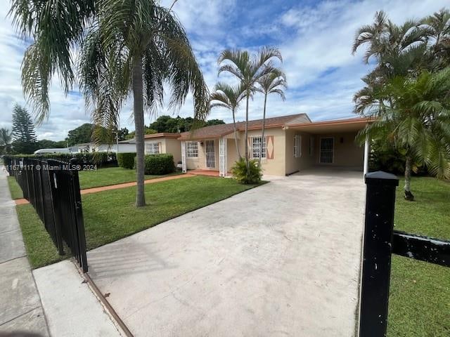 ranch-style home with a front yard and a carport