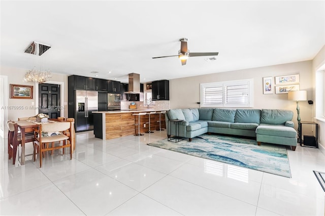 living room featuring ceiling fan, light tile patterned floors, and sink