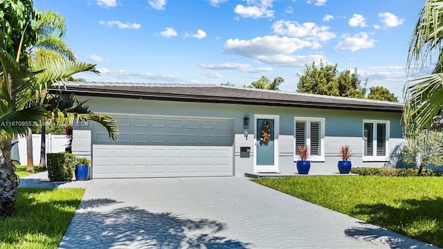 single story home featuring a front lawn and a garage