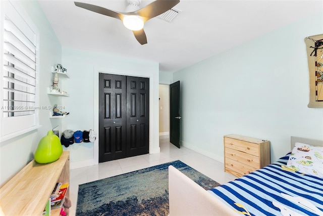 bedroom featuring light tile patterned flooring, a closet, and ceiling fan