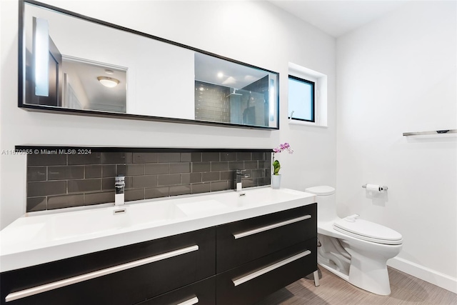 bathroom featuring walk in shower, hardwood / wood-style floors, toilet, decorative backsplash, and vanity