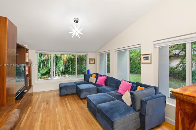 living room with light hardwood / wood-style flooring, a wealth of natural light, and lofted ceiling