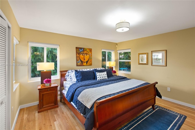 bedroom with light hardwood / wood-style flooring and multiple windows