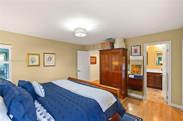 bedroom featuring light hardwood / wood-style floors and ensuite bathroom