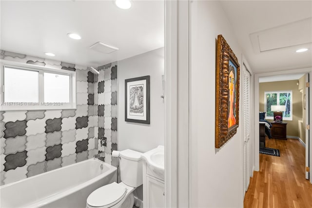 full bathroom featuring hardwood / wood-style floors, vanity, shower / tub combo, and toilet