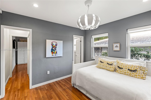 bedroom featuring hardwood / wood-style flooring and a chandelier