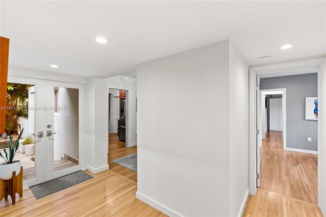 corridor featuring french doors and light wood-type flooring