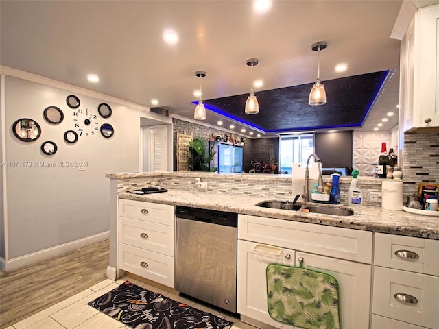 kitchen featuring light stone counters, white cabinets, dishwasher, and sink