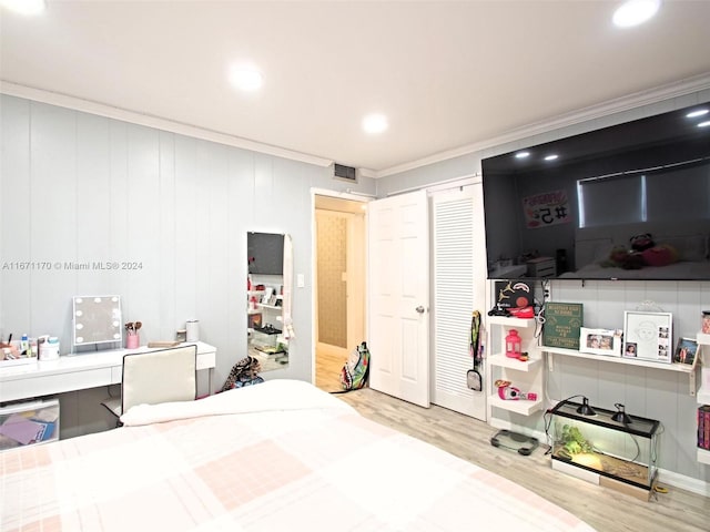 bedroom featuring crown molding, hardwood / wood-style floors, and a closet