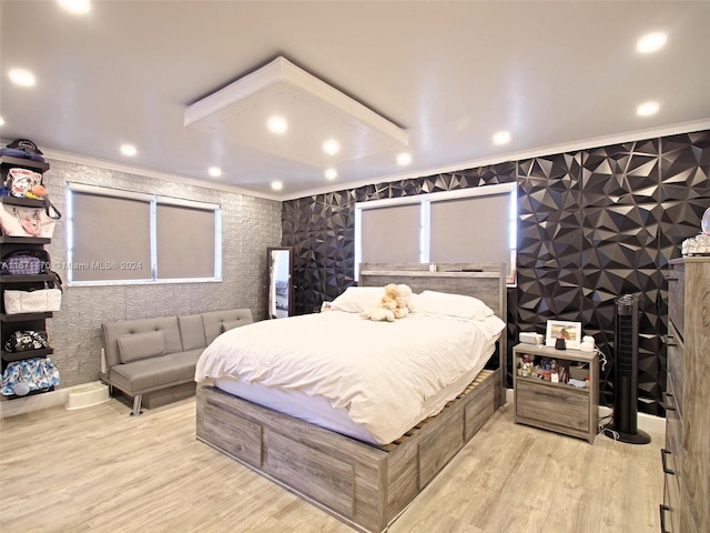 bedroom with ornamental molding and light wood-type flooring