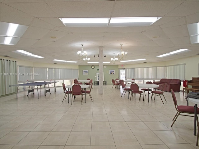 dining space with a drop ceiling and a chandelier