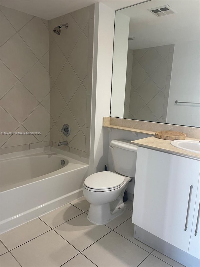 full bathroom featuring toilet, vanity, tiled shower / bath combo, and tile patterned floors