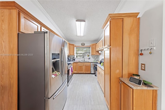 kitchen with sink, ornamental molding, a textured ceiling, and appliances with stainless steel finishes