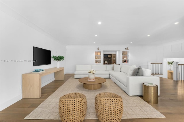 living room with hardwood / wood-style flooring and crown molding