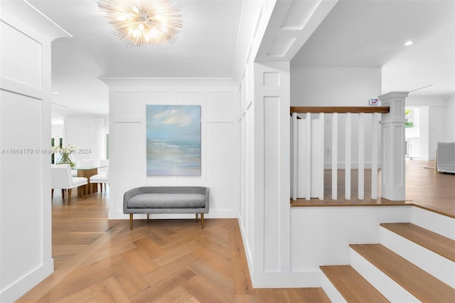 stairway featuring an inviting chandelier and parquet floors