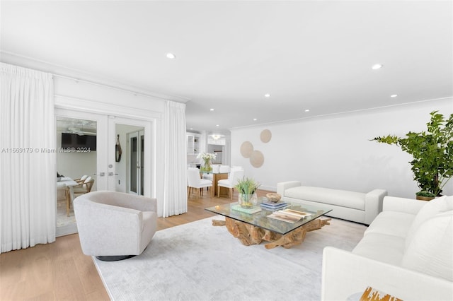 living room with ornamental molding and light wood-type flooring