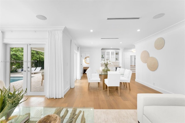 dining area with light wood-type flooring and french doors