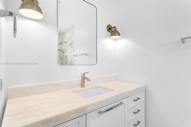 bathroom featuring tiled shower and vanity