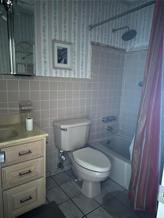 full bathroom with vanity, shower / bath combo, tile patterned floors, tile walls, and toilet