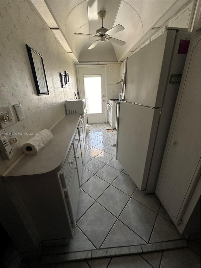 kitchen with light tile patterned floors, white appliances, white cabinetry, and ceiling fan